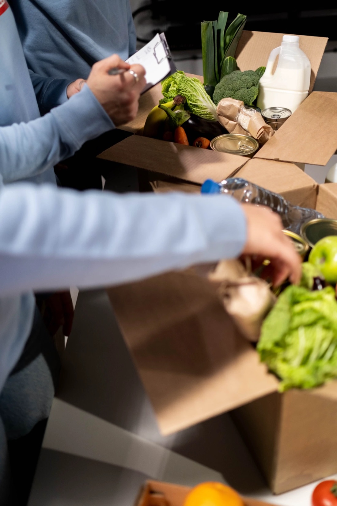 Volunteers filling a box of groceries